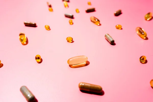 Top view of pills on pink pink background with harsh shadows. Trendy flatlay of preventive medicine
