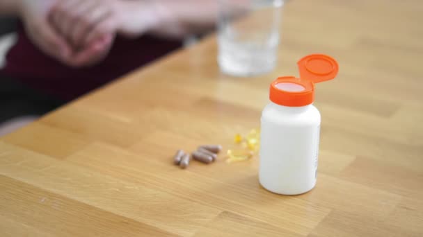 Les femmes mains avec des suppléments pilules et un verre d'eau. Auto-soins avec médecine préventive — Video