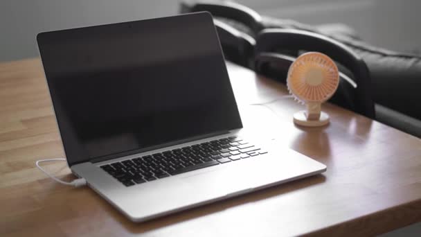 Mini ventilador USB cerca de la computadora portátil. Día de oficina de verano. Mini refrigerador portátil — Vídeo de stock