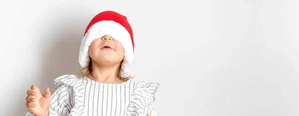 圣诞节时戴红帽子的蹒跚学步的小女孩的画像。惊喜的概念 — 图库照片