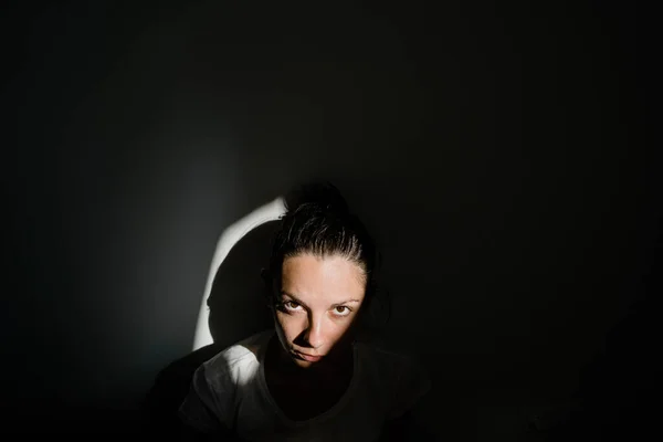 어두운 방에서 혼자 햇빛 주머니에 앉아 있는 소녀. 정신 건강 개념 — 스톡 사진