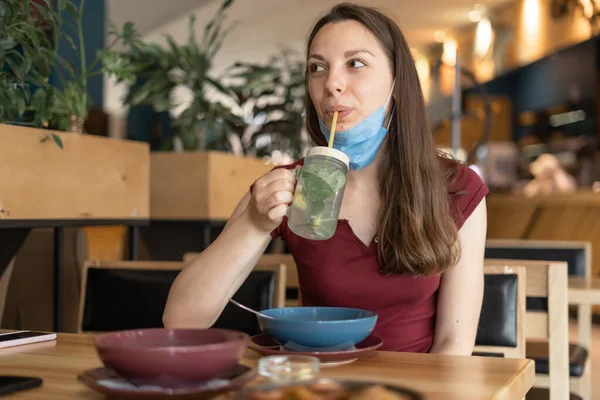 Novo conceito normal de mulher com máscara comendo no restaurante — Fotografia de Stock