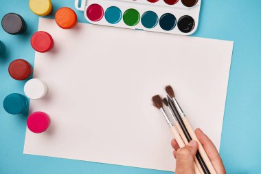 Boya ve fırçanın üst görüntüsü. Tuval maketi. Okul masası manzarası. Sanat sınıfı