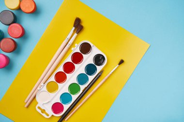 Boya ve fırçanın üst görüntüsü. Tuval maketi. Okul masası manzarası. Sanat sınıfı