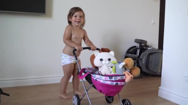 En liten flicka som leker med en leksaksvagn hemma. hemundervisning, låtsaslek. — Stockvideo