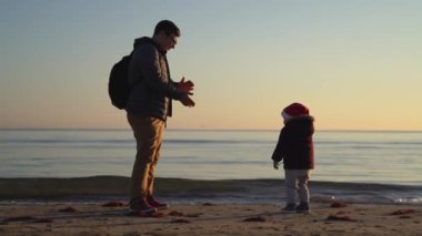 Soğuk kış havasında baba ve çocuk deniz kenarında. Noel günü. Açık havada kaynaşma zamanı