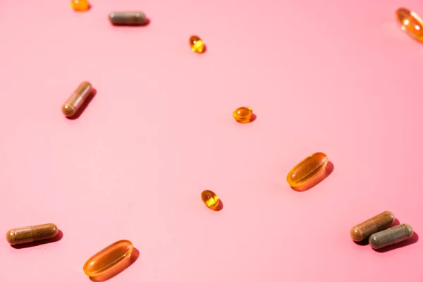Top view of pills on pink pink background with harsh shadows. Trendy flatlay of preventive medicine