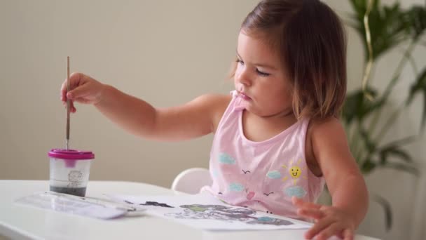 Niña caucásica pintando con pintura de acuarela en casa sola. Desarrollo temprano creativo. — Vídeos de Stock