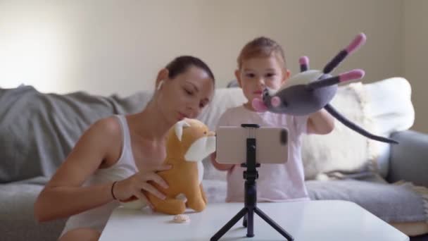 Mor med barn streaming online video av utpakking klær. Influencer-jobb, mammablogg – stockvideo