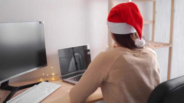 Kaukasierin arbeitet im Büro mit Laptop und schläft ein. Müder, gelangweilter Arbeiter an Heiligabend. — Stockvideo