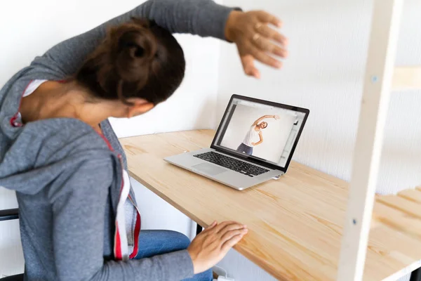Жінка розтягує йогу в офісі онлайн-спортивним відео. Фітнес на роботі . — стокове фото