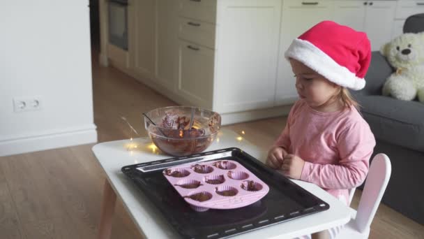 Menina da criança cozinhar biscoitos de chocolate de Natal em chapéu de santa. Férias atividades tradicionais casa com crianças — Vídeo de Stock