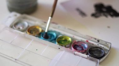 Suluboya boya paletini boya fırçasıyla kapat. Çocuklar için yaratıcı aktivite. Hobi sınıfı