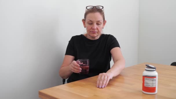 Caucasian middle aged woman taking vitamins and supplements at home. Omega 3, vitamin d, magnesium, — Stock Video