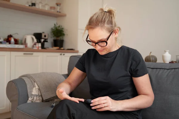 Blanke vrouw van middelbare leeftijd die een bloedglucosetest doet. Diabetische werelddag. Insulineresistentie, metabool syndroom — Stockfoto