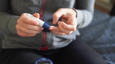 Glikoz sayacıyla genç kadın ellerine yaklaş. Evde kan testi var. Metabolik sendrom