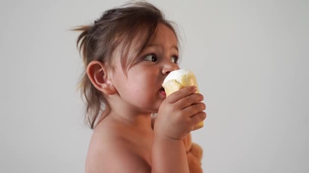 自宅でアイスクリームを持つ子供の幼児の女の子。おいしい甘い食べ物。面白い顔だ — ストック動画