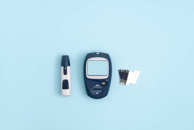 Glucose meter and pen on blue background, top view. Metabolic syndrome concept clipart