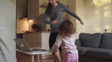 Evde mutlu aile dansı. Anne ve kızı birlikte eğleniyorlar.