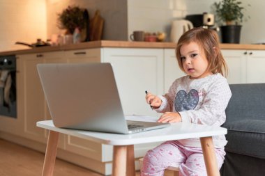 Küçük kız evde e-öğreniyor. Anaokulu çevrimiçi sınıfı.