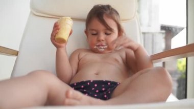 Evde dondurması olan küçük bir kız çocuğu. Lezzetli tatlı yiyecekler. Komik surat.