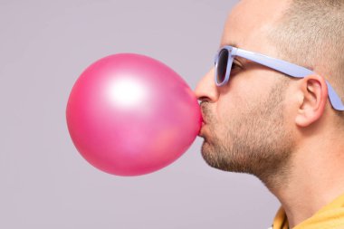 Pembe sakız şişirme mor gözlüklü adam