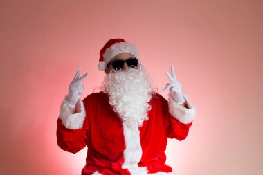 Santa parlak pembe bir arka plan karşı güneş gözlüklü