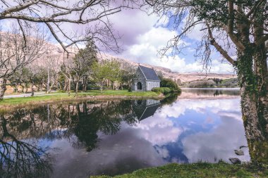 Gouganebarra göl ve nehir Lee county Cork, İrlanda için Saint Finbarr hitabet Şapel dışında görünümü.
