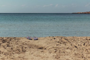 Plaj sandaletleri turkuaz su ile Yunan bir plaj önünde terk
