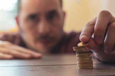 Adam paralar bir ahşap masa üstünde istifleme odak dışı: Emlak, gayrimenkul yatırım, evi ipotek, tasarruf mali kavramı.