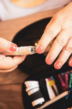 Kadın el lancet şekeri ölçüm cihazı tarafından kan şeker seviyesini kontrol etmek için bir parmağına kullanarak yakın çekim