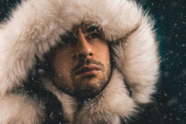 Ararken kar ile eskimo bir ceket giymiş beyaz bir adam portresi kapatın