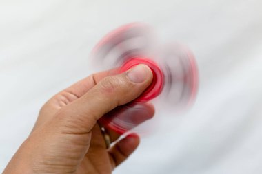 Bir kırmızı topluca spinner beyaz bir arka planda tutan el