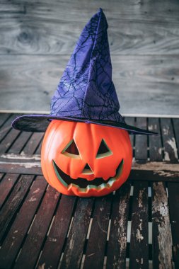 Jack O Lantern cadı mor şapkalı yaşlı bir ahşap masa üstüne konuyor
