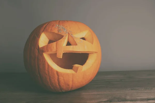 Una Calabaza Tallada Sobre Una Mesa Madera Sobre Fondo Gris —  Fotos de Stock