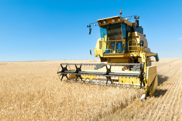 Комбайн на переднем плане на ржавом фоне, работающий в темноте
