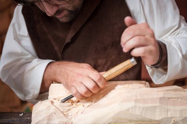 Wood worker with hand gouge working the Pin clipart