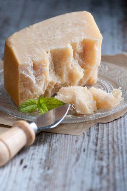 Yaşlı ahşap tabl üzerinde ön planda kurutulmuş peynir