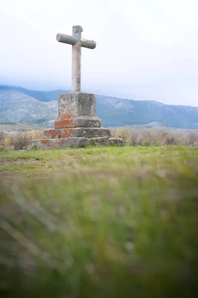 Christian cross carved in granite stone in the foregroun — Stock Photo, Image