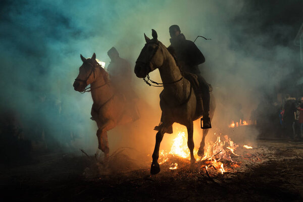 Horse passing over the bonfire, as a tradition to purify the soul of animals, in the celebration carried out in the town of San Bartolom de Pinares, province of Avila, Spain, on January 