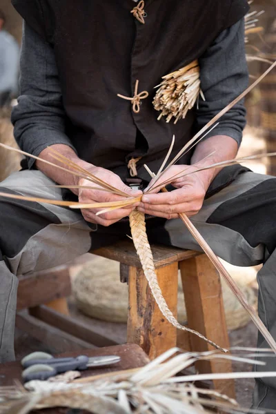 Vecchio artigiano di vimini con le mani che lavorano in foregroun isolato — Foto Stock