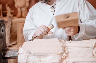 Ön plandaki zanaatkar Han 'ın aletleri ve çekiciyle çalışıyor.