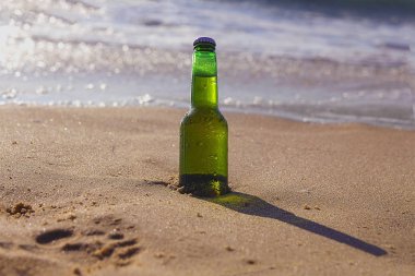 bir şişe bira denizde