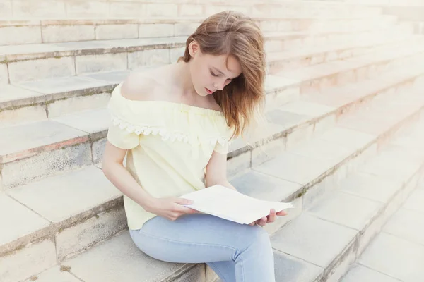 若い美しい女性学生を階段で読んでいます ライフ スタイルの肖像画 — ストック写真