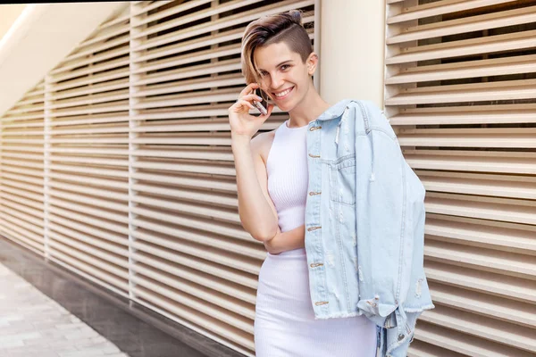 Young smiling woman speaks by phone. Lifestyle portrait