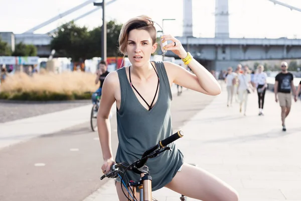 Young woman with bicycle and headphones on city street. Lifestyle Concept