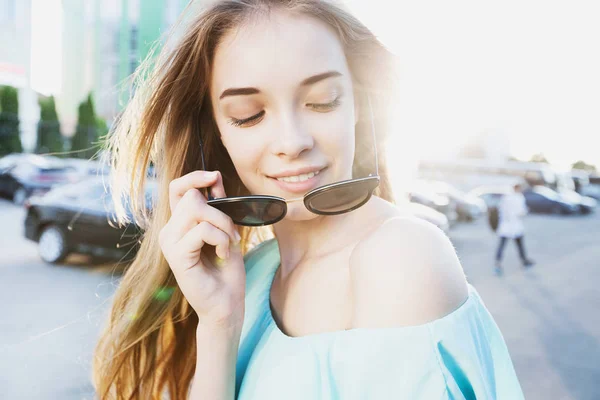 日当たりの良い通りに笑顔のサングラスをかけた謎の美少女 ライフ スタイルのコンセプト — ストック写真