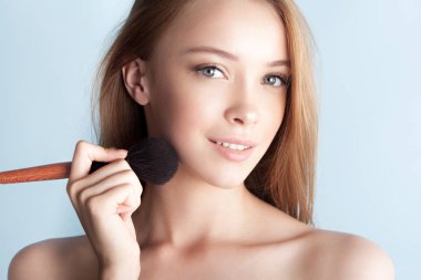 Toz yakın çekim için fırça ile genç güzel kız. Güzellik Portresi