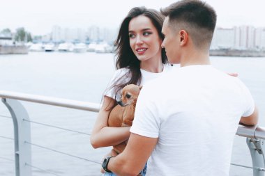 Genç mutlu çift yürüyüş ile küçük köpek. Yaşam tarzı kavramı