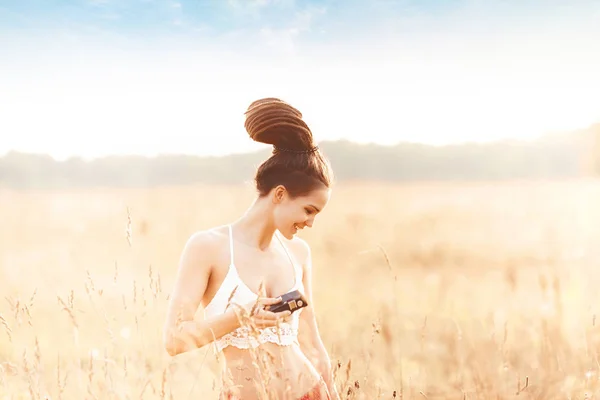 年轻迷人的女孩与相机在野外在日落 户外浪漫概念 — 图库照片